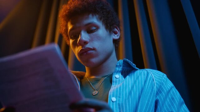 Biracial teenager reading script, rehearsing theatrical monologue backstage. Clip suitable for drama school advertising, acting workshop promotion, audition reels
