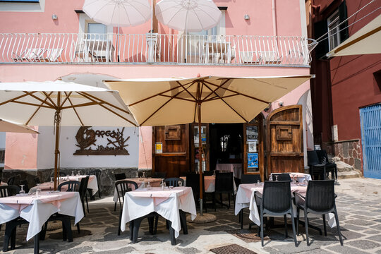 Procida, Italy - August 7, 2026. Outdoor Restaurant Terrace of Ristorante Gorgonia in Marina di Corricella, Procida. A sunny daytime view of the outdoor dining patio at Ristorante Gorgonia along the w