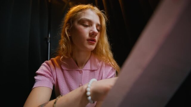 Caucasian teenage girl reading theater script backstage preparing for acting audition. Footage ideal for drama school advertising and performing arts campaigns