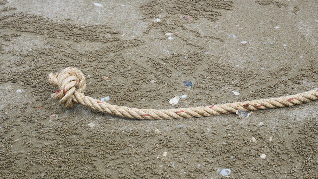 Close-Up of Knotted Rope End on Sandy Beach