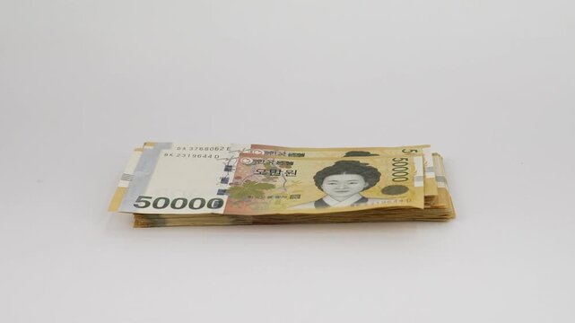 Close-up Fixed Shot of Hands Counting Crisp South Korean 50,000 Won Banknotes (Cash, Finance, Wealth)