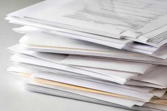A stack of white papers is piled on a light-colored surface.