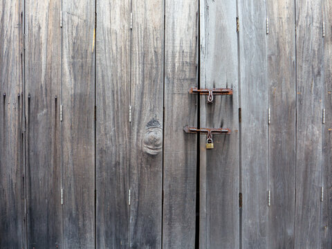 Vintage Wooden Folding Door with Rusty Latches and Padlock
