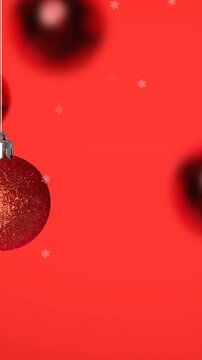 Animation of snow falling over christmas bauble decorations on red background