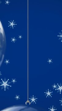 Animation of snow falling over christmas bauble decorations on blue background