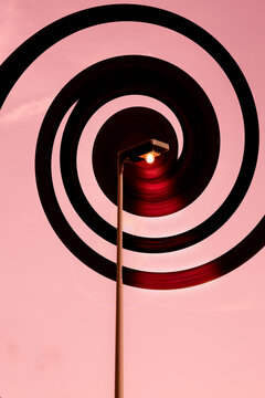 lampadaire au centre d'une composition graphique en spirale rose et noire