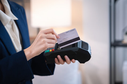Financial advisor holding payment card near electronic terminal supports secure wealth planning for business transaction with professional service and modern contactless payment technology