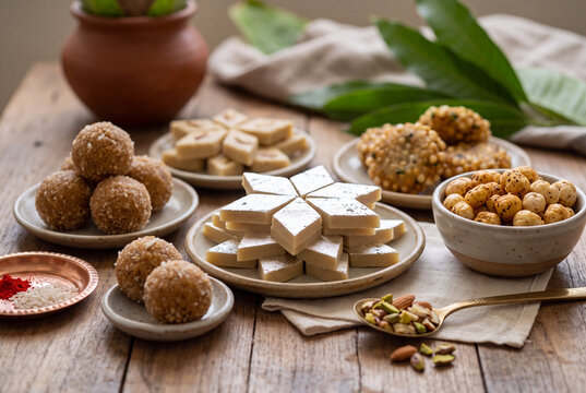 Assorted indian mithai sweets on a wooden table for diwali festival offering and festive food background
