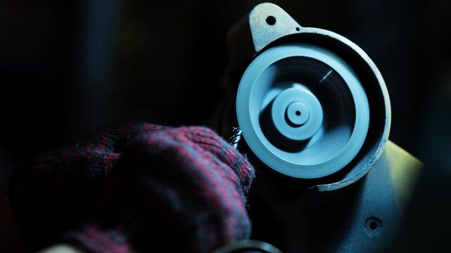 industrial worker operating metal grinding machine for precision processing