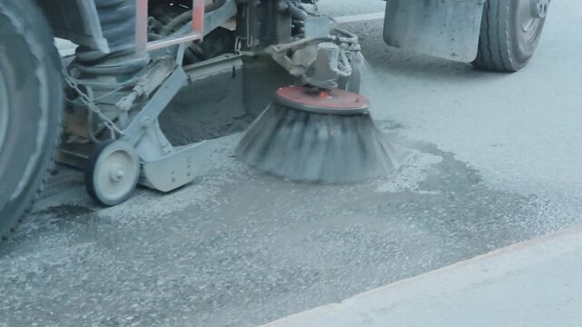 municipal sweeper truck washing and cleaning a city street road surface from dust and dirt. Public utilities maintenance concept.