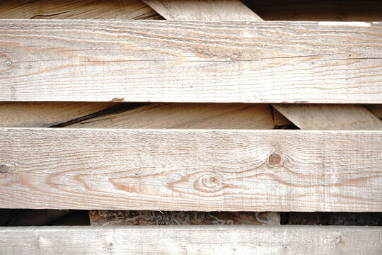 Weathered wooden planks with visible grain and knot detail stacked horizontally