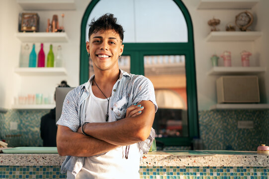 Friendly young service worker smiling confidently, ready to provide excellent customer service