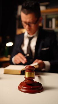 Scales of Justice with Blurred Lawyer Reading Document in Law Office