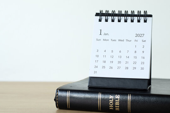 January first 2027 calendar year and holy bible with white background. Christian resolution, goals, study, and education concept. Copy space.