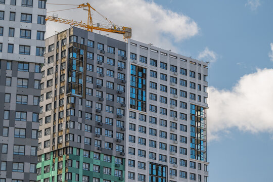Urban skyline transformation captured under a bright blue sky with fluffy clouds as a building emerges towards completion