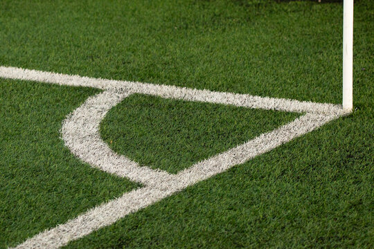 Football corner area on an artificial turf field, with white boundary and corner lines clearly visible, outdoor soccer pitch