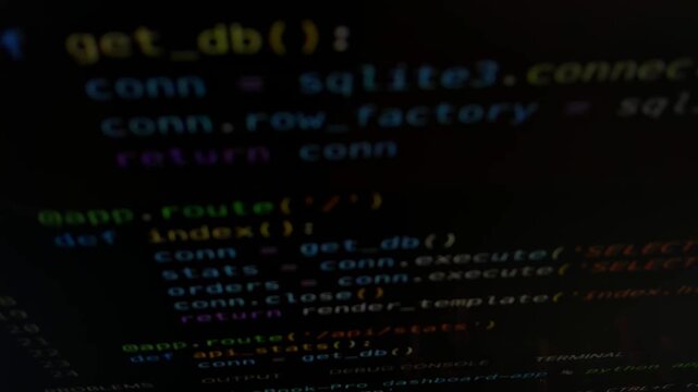 Software developer writing python code on a computer screen for web application development, connecting to a sqlite database and serving a flask application with debug mode