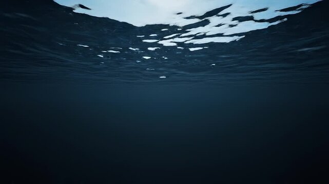 Underwater surface ripples with light rays shining down in deep blue ocean depths