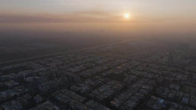 Hazy sunrise aerial view over Sector E-11 residential community and Margalla Road in Islamabad