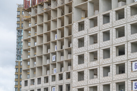 Construction progresses on a modern multi-story building with visible concrete frames in an urban setting