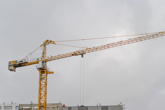 Construction crane towers against a moody sky showcasing urban development in progress