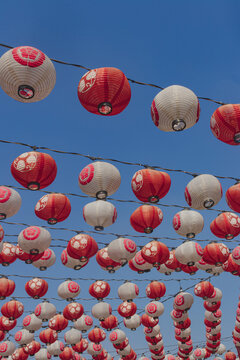 Japanese Chochin Paper Lanterns with Floral Crest Motifs Against Blue Sky