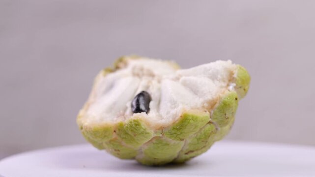 Close-up of a sugar apple (custard apple) cut in half, showing its white flesh and natural texture in detail.