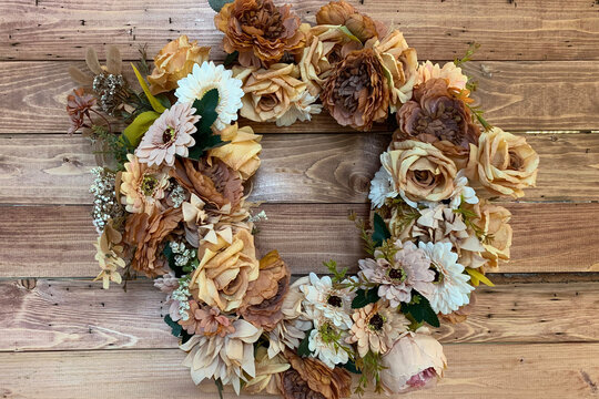 Autumn floral wreath hanging on wooden wall. Fall seasonal decoration.