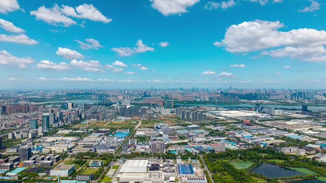 Aerial view of the modern industrial zone and urban skyline in Wuhan China under a bright blue sky with white clouds
