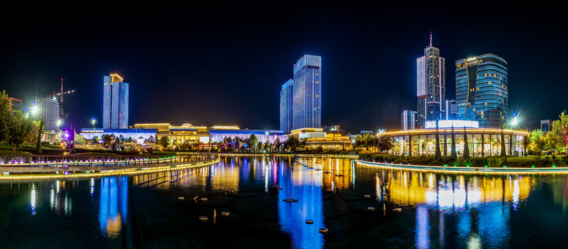 View of Tashkent City Park at night with illuminated modern skyscrapers reflecting in the calm lake, showcasing contemporary architecture in Tashkent, Toshkent, Uzbekistan.