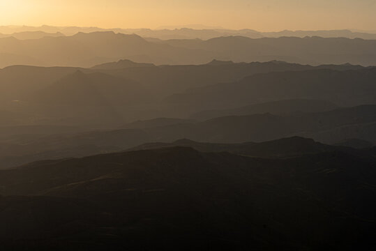 View of Gorakh Hill Station with layered mountain ridges silhouetted against a golden sunset sky in Johi, Dadu District, Pakistan.