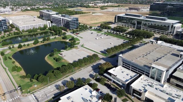 Dual aerated retention ponds grace landscaped corporate grounds across Collin County Texas. Multi level parking garage borders corporate office blocks throughout expanding Frisco, Texas