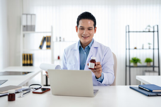 Confident asian doctor talking on video call by looking at camera from hospital with patients. concept of online counseling, medical advice and consultation.