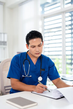 male doctor reviewing patient medical charts at the clinic office.