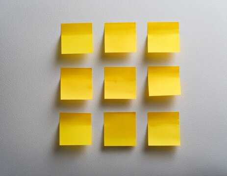 nine yellow sticky notes arranged in a grid on a white wall