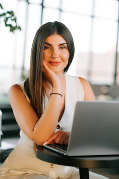 Professional woman using a laptop at a table indoors