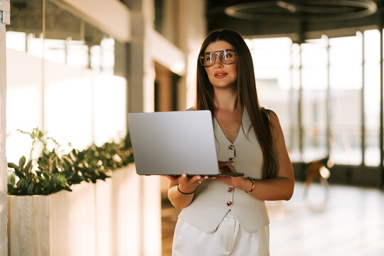 Woman with laptop working in a bright office