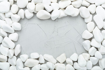 White pebble stones on concrete background, top view © Liami