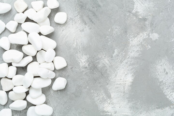 White pebble stones on concrete background, top view © Liami