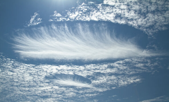 A Pair Of Rare Elliptical Fallstreak Hole Clouds In The Sky Over The South Of England UK Caused By Evaporating Supercooled Water, Sometimes Confused WIth UFOs