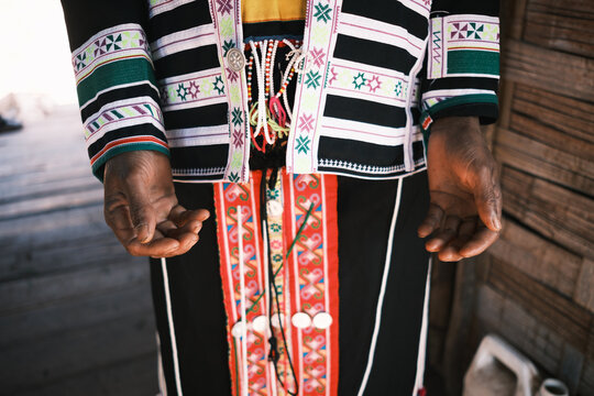 View of a person wearing traditional Hmong clothing with intricate embroidery and colorful patterns in Laos.