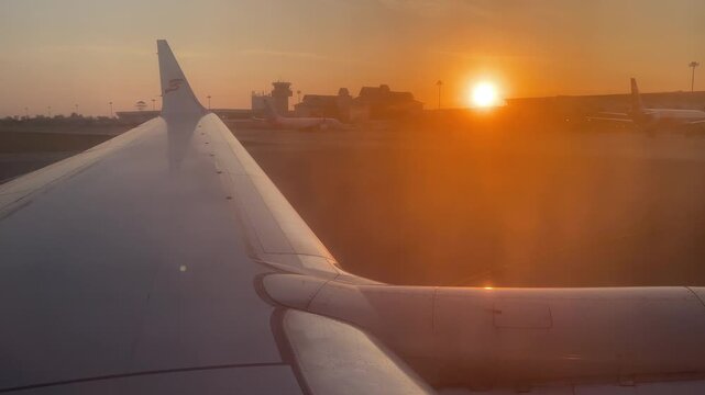 air plane wing from window on sunset background