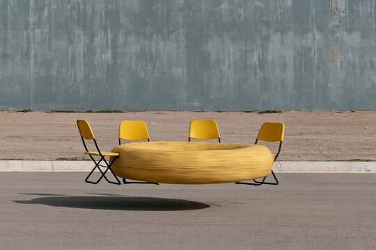 Yellow folding chairs surrounding a blurred spinning yellow object on a grey asphalt surface, an abstract symmetrical composition for art and design