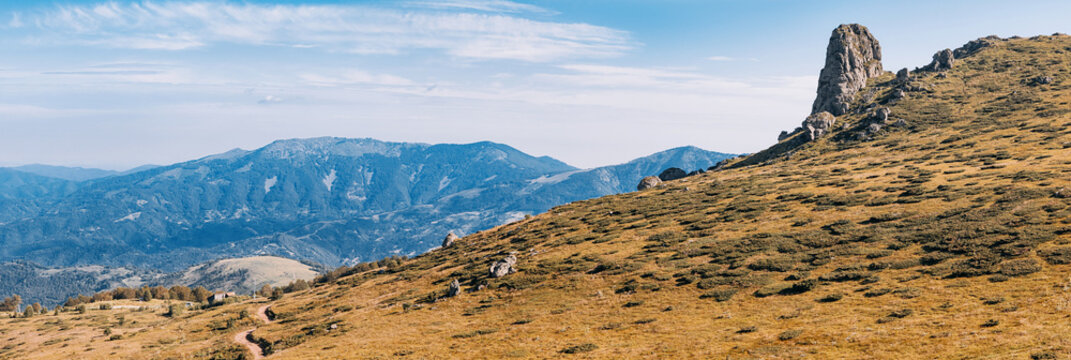 Wide open mountain ridgeline with rocky pinnacle Babin Zub and layered valley views in Stara Planina park, Serbia. Ideal for adventure travel and hiking campaigns.