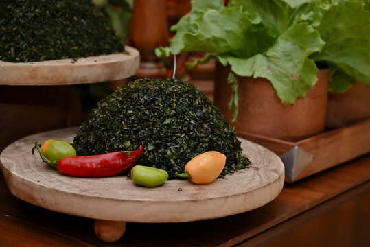 finely chopped couve collard greens, red pimenta dedo de mo&ccedil;a peppers, green lettuce, and rustic decorations on feijoada buffet table, catering display horizontal shot