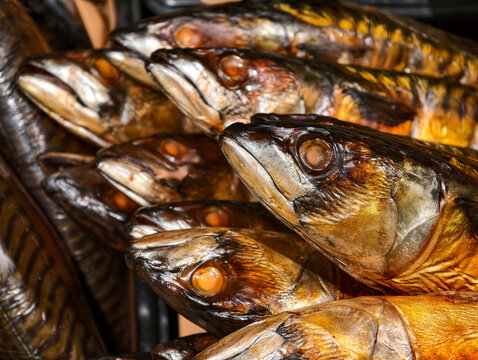 Hot smoked mackerel with head and gutted body presented on a supermarket fish display, highlighting a prepared seafood product for customers