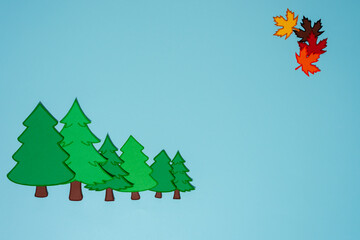 Vibrant, colorful leaves gracefully drift down from the trees, creating a beautiful scene against a clear blue sky © Luis