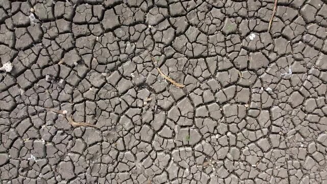 An aerial view of a dried up and cracked lake bed exposed by heat wave and drought conditions.