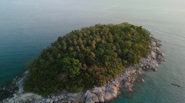 Aerial view shows Ko Pu Island with green trees and rocky shores in the blue Andaman Sea