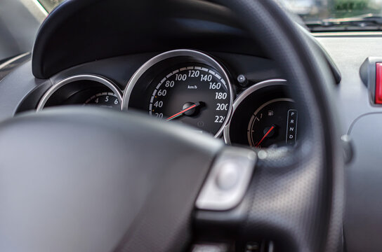 Modern car dashboard showing the speedometer, gauge cluster, and steering wheel.